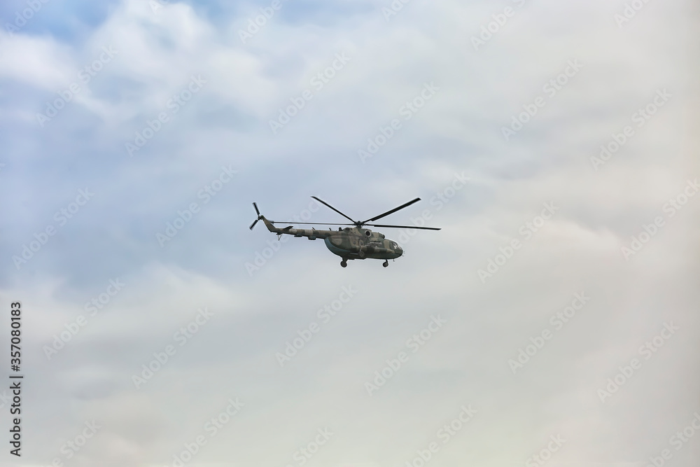 Distant view of military helicopter flying in sky Distant view of military helicopter flying in sky