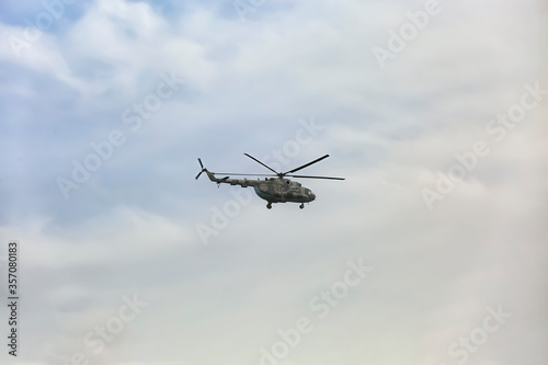 Distant view of military helicopter flying in sky