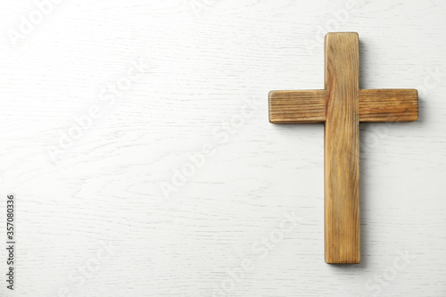 Print op canvas Christian cross on white wooden background, top view with space for text