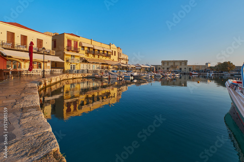 the quay of the historic port of Rethimno in the morning sun, boats in the port and empty restaurants
