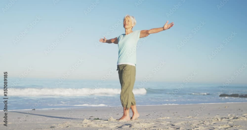 Senior Caucasian woman enjoying time at the beach with sea in the background Senior Caucasian woman enjoying time at the beach with sea in the background
