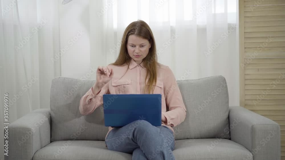 Slowmo of confident young woman pressing key on laptop keyboard and money falling on her from above. Slow motion. Concept of online income, remote work, freelance, success, wealth, richness. Slowmo of confident young woman pressing key on laptop keyboard and money falling on her from above. Slow motion. Concept of online income, remote work, freelance, success, wealth, richness.