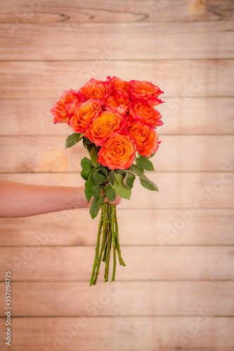 Women hand holding a bouquet of Free Spirit roses variety, studio shot.
