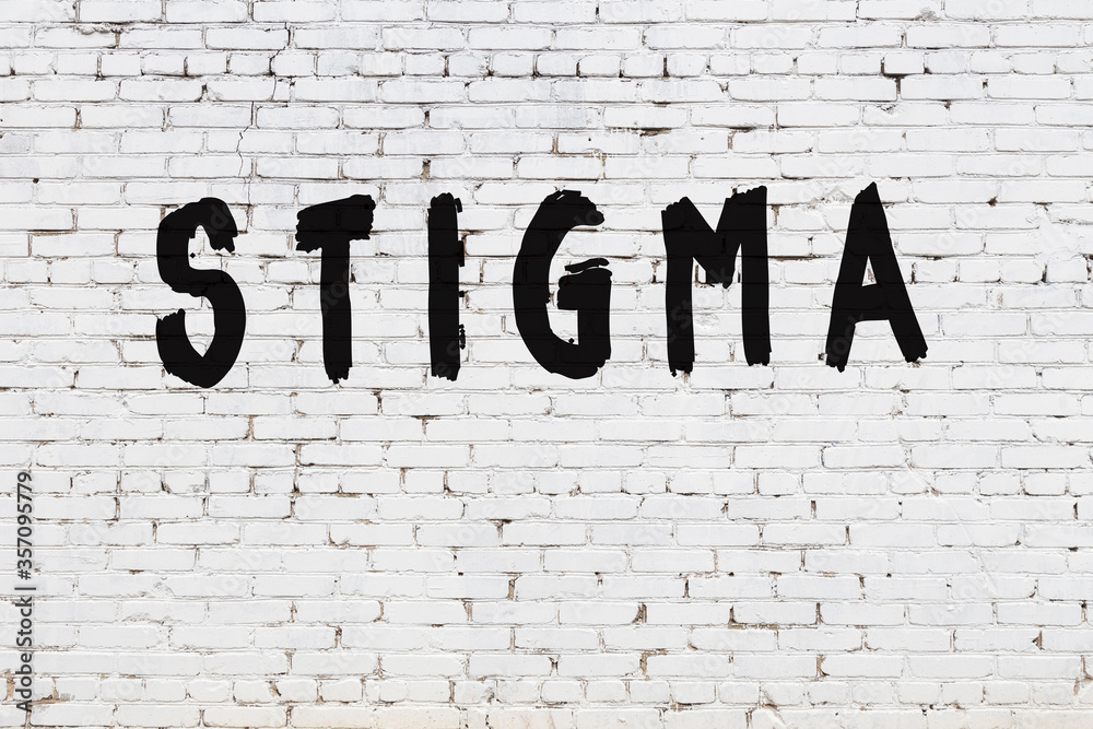 Φωτογραφία White wall with black paint inscription stigma on it