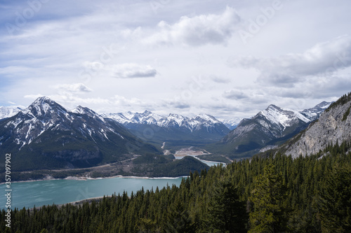 View on snowy mountain peaks and forest valley with lake, shot in Canadian Rockies at Prairie View Trail, Kananaskis, Alberta, Canada © Peter Kolejak