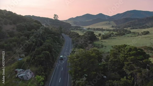Aerial flying over country road and car driving. Elliot bay, Northland, New Zealand photo
