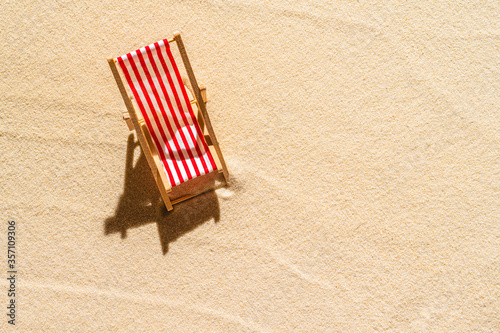 Aerial view of one deck chair, sunbed, lounge on sandy beach. Summer and travel concept. Minimalism