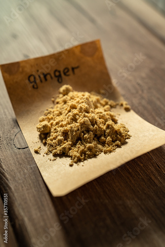 Heap of dry ginger powder on craft paper sheet. Aromatic spice.