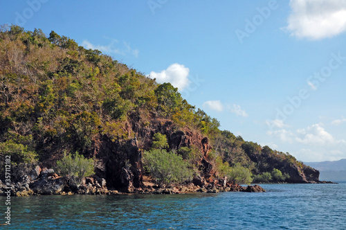 Rock formation with trees and blue water sea