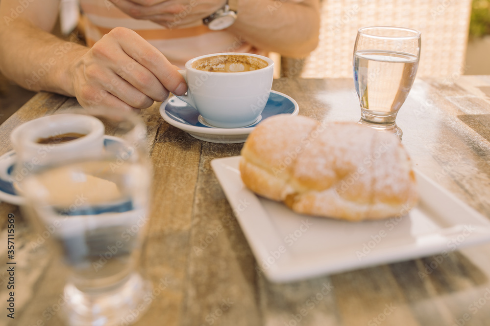 Breakfast with croissant and coffee on summer terrace on sunny day. Breakfast with croissant and coffee on summer terrace on sunny day.