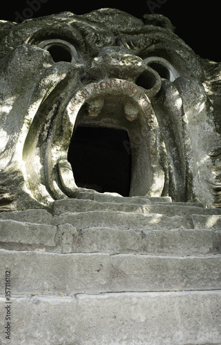 sixteenth century era volcanic rock statue of monster orcus with open big mouth in the village Bomarzo wood park close to Rome   photo