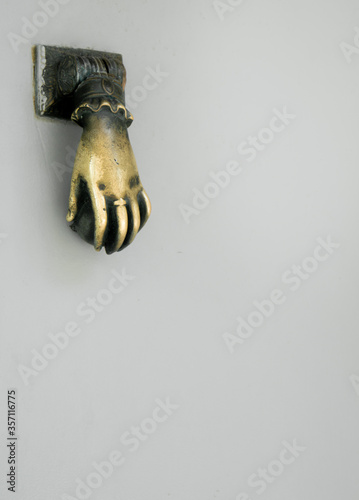 a golden hand for knocking on the door with a white background