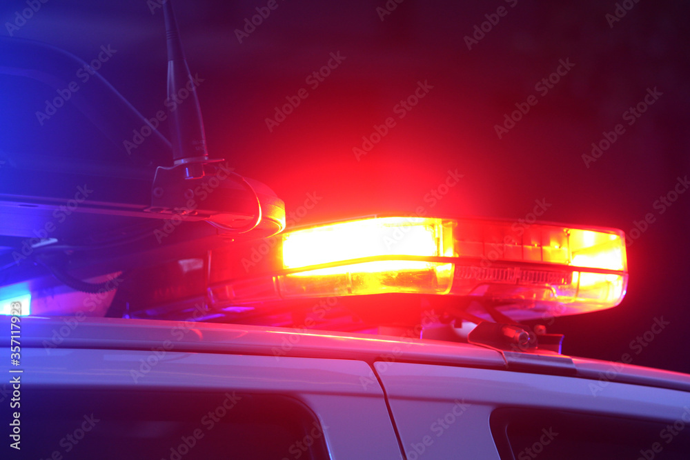 Flashing emergency lights at night. They are red and on the top of a