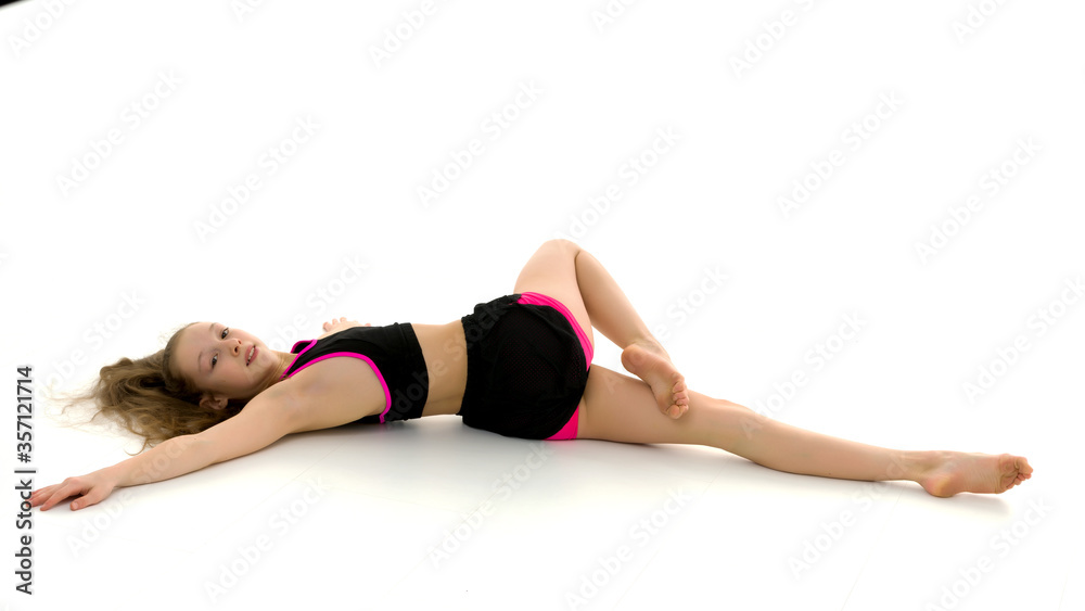 Charming little girl doing gymnastic exercises in the studio on a white background Charming little girl doing gymnastic exercises in the studio on a white background