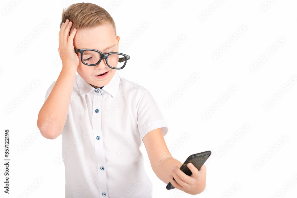 Portrait of boy with glasses using mobile phone on white background. Modern mobile communications