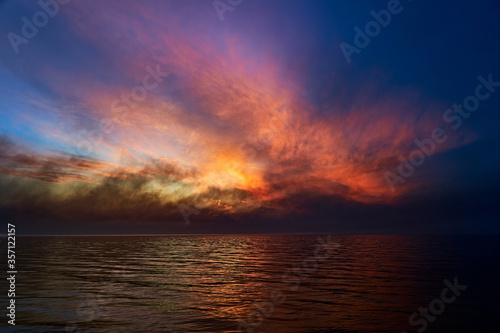 Sea sunset. Smoke wildfires sweeping across the sky.