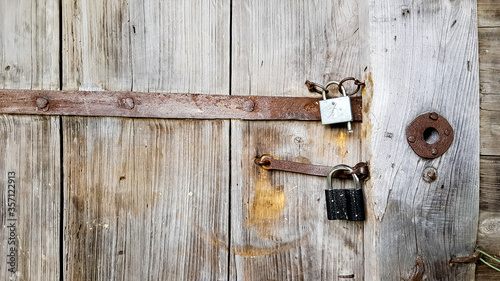 Old vintage metal padlock on a closed wooden door of an old farmhouse. The true style of the village. close-up. focus on the castle. Wooden background, texture. Copy space