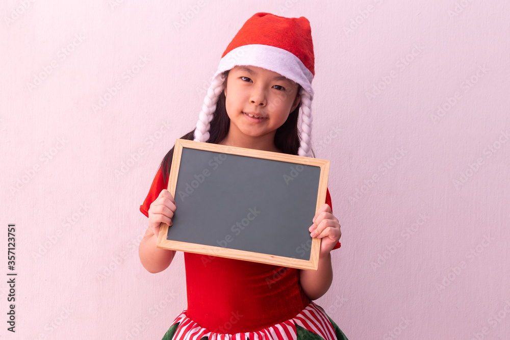 Asian girl in Elf clothes holding empty board. Merry christmas Asian girl in Elf clothes holding empty board. Merry christmas
