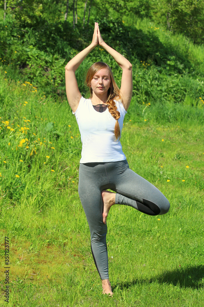 Young woman of European appearance does yoga in summer nature Young woman of European appearance does yoga in summer nature