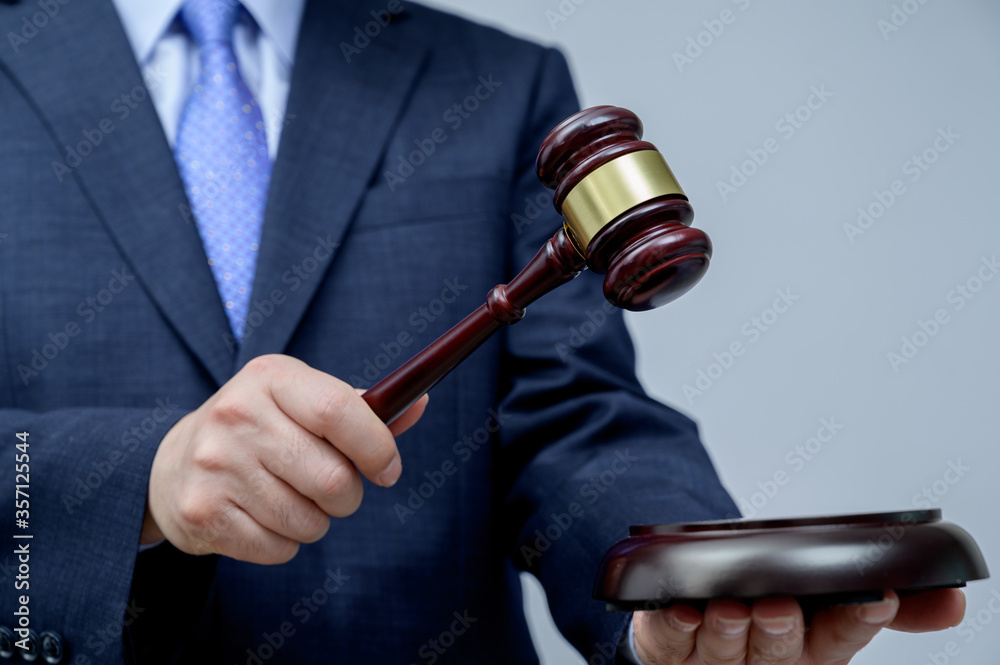 Male businessman holding a gavel in hand. justice and auction concept.