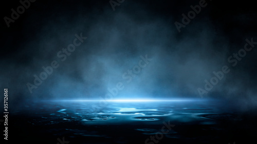 Dark dramatic abstract scene background. Neon glow reflected on the pavement. Smoke, smog and fog. Dark street, wet asphalt, reflections of rays in the water. Abstract dark blue background.  photo