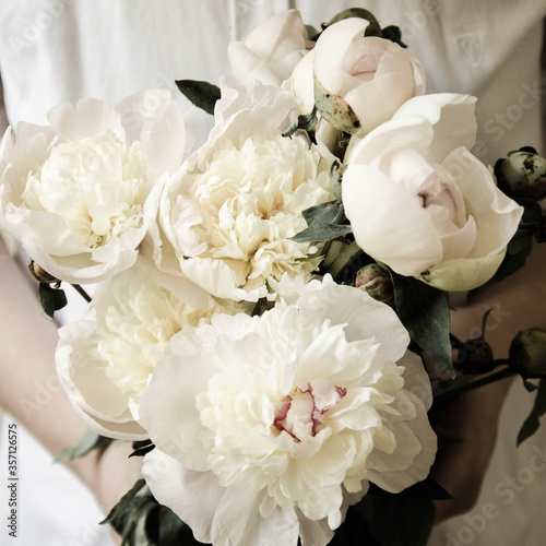 Beautiful bouquet of white peonies in hands