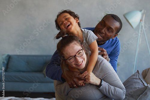 Portrait of a young multiracial family having fun at home.