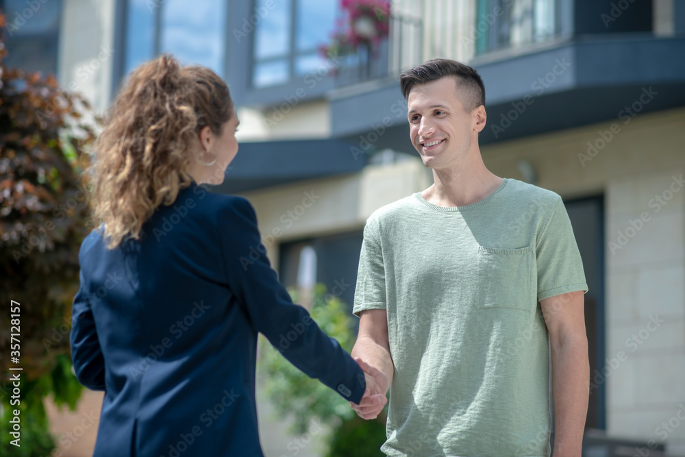 Elegant businesswoman shaking hands with her smiling client