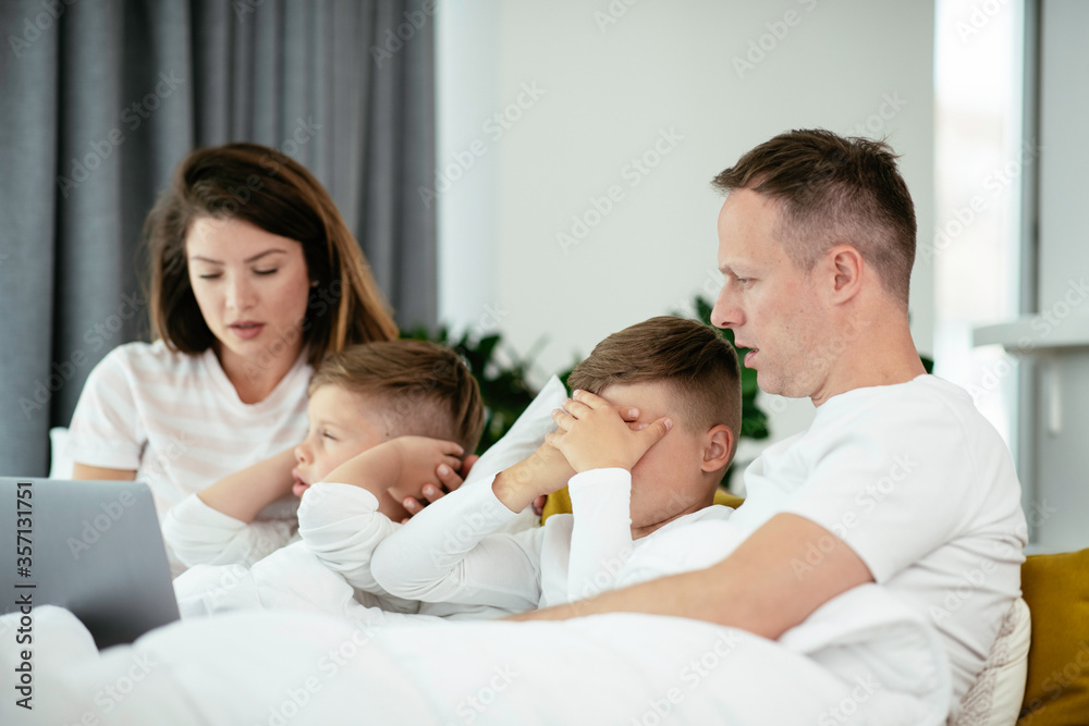 Young family watching movie on lap top. Beautiful parents with kids enjoying at home. Young family watching movie on lap top. Beautiful parents with kids enjoying at home.