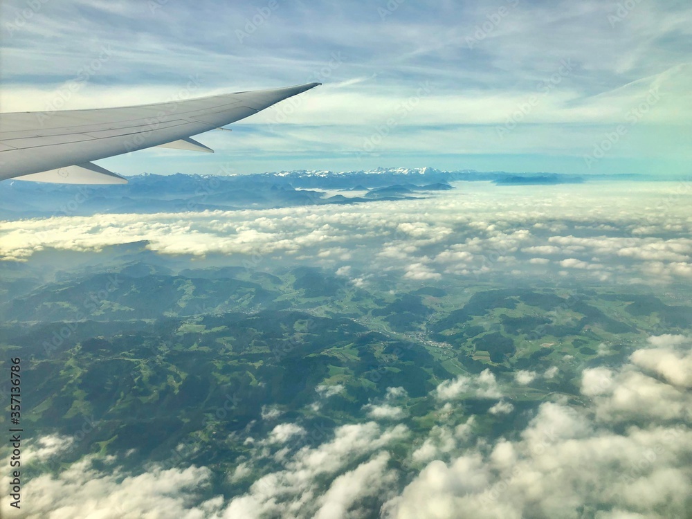 Looking out the window, flying over switzerland with the swiss alps in the background Looking out the window, flying over switzerland with the swiss alps in the background