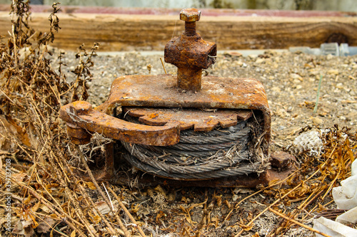 фотографія Old rusty winch with ratchet and pawl mechanism and a steel cable rolled up insi