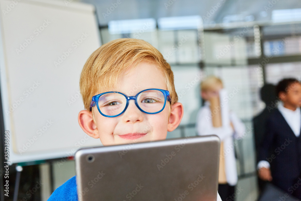 Smiling kid with tablet computer as a nerd Smiling kid with tablet computer as a nerd