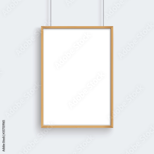 Wooden frame with poster mockup hanging on gray wall.