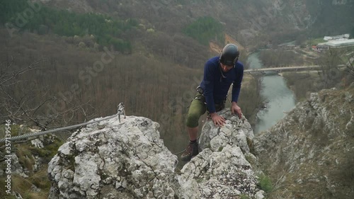 A Hiker Climbing On Top Of The Rock In Casa Zmeului In Romania - close up photo