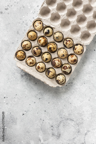 Eggs on a tray on the kitchen table. Quail eggs on a culinary background. Concept of preparation for baking. Top view with space for text