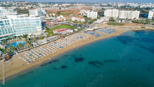 Aerial bird's eye view of Sunrise beach Fig tree, Protaras, Paralimni, Famagusta, Cyprus.The famous tourist attraction family bay with golden sand, boats, sunbeds, restaurants, water sports from above