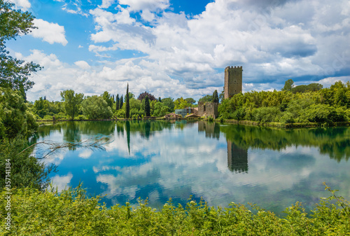 Garden of Ninfa, (Lazio, Italy) - A natural monument with medieval ruins in stone, flowers park and an awesome torrent with little fall. Province of Latina, central Italy. Here the little lake. photo