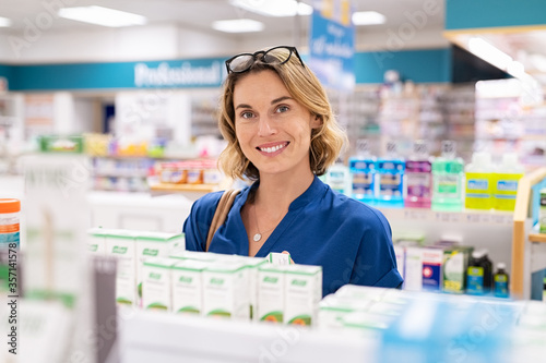 Smiling woman buying cosmetic product at pharmacy photo