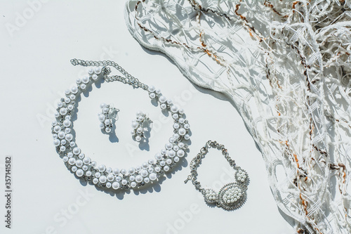 Fototapeta Naklejka Na Ścianę i Meble -  pearl jewelry (earrings and necklaces) next to the short dress. White background