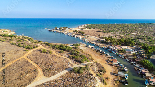 Aerial bird's eye view Liopetri river to sea (potamos Liopetriou), Famagusta, Cyprus.Fjord landmark tourist attraction fishing village with colourful boats moored on banks at Kokkinochoria, from above © f8grapher