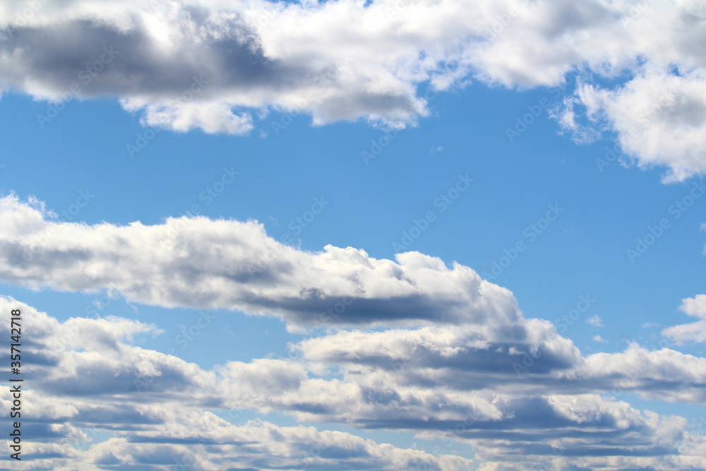 White fluffy clouds on a background of blue sky in summer. The concept of weather and climate White fluffy clouds on a background of blue sky in summer. The concept of weather and climate