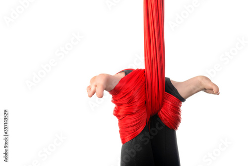 Close-up of a little girls legs tied in a knot of red airy ribbons on a white background. Concept of aerial acrobatics and sporting achievements. Advertising space photo