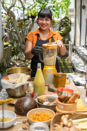 jamu herbal drink. asian woman jamu maker with spice ingredient