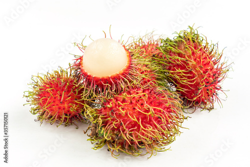 Small group of rambutanSmall group of rambutan with one peeled half rambutan put on top. Isolated close up image on white background. Close up tropical fruits of Thailand.