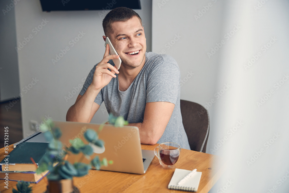 Attractive brunette male laughing while talking on phone Attractive brunette male laughing while talking on phone