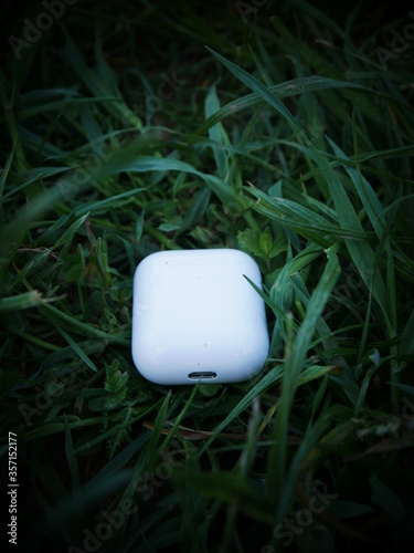 white wireless headphones on grass background