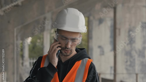 Construction engineer talking on the phone in a building under construction