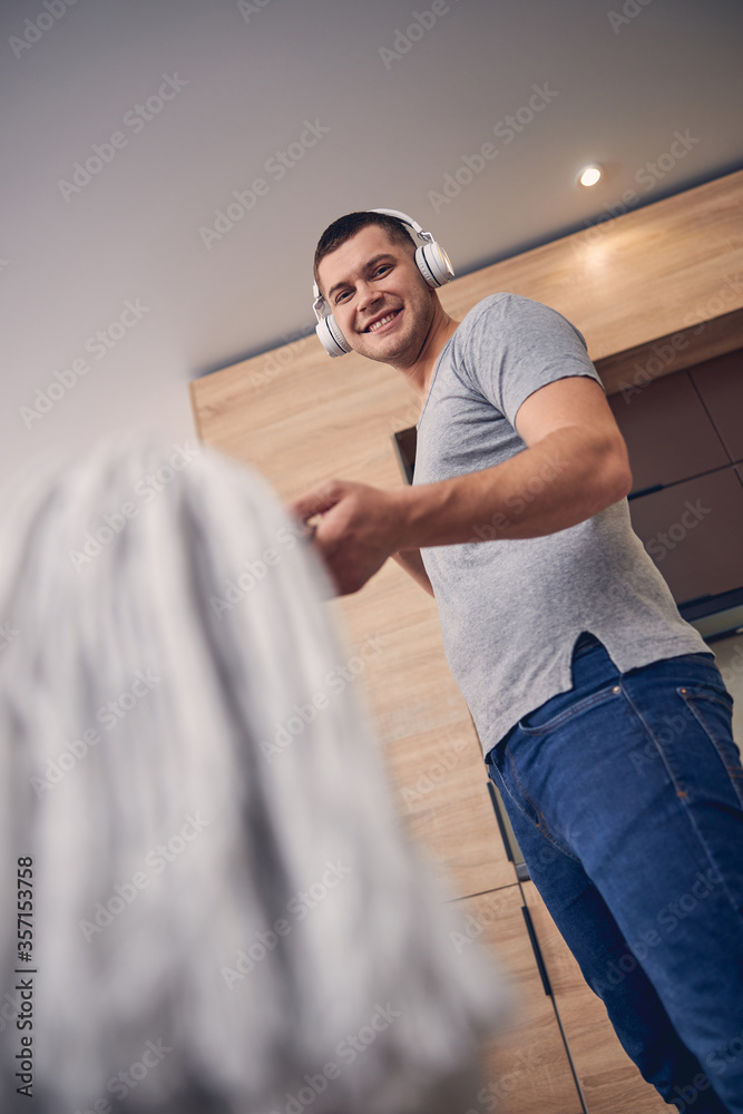 Attractive young male smiling while showing mop Attractive young male smiling while showing mop