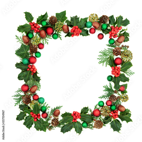 Fototapeta Naklejka Na Ścianę i Meble -  Square Christmas wreath decoration with holly, red & green bauble decorations & winter greenery on white background. Decorative abstract border for the festive season.