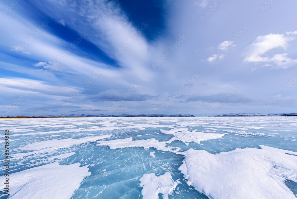 Frozen Lake Baikal. Beautiful stratus clouds over the ice surface on a frosty day.